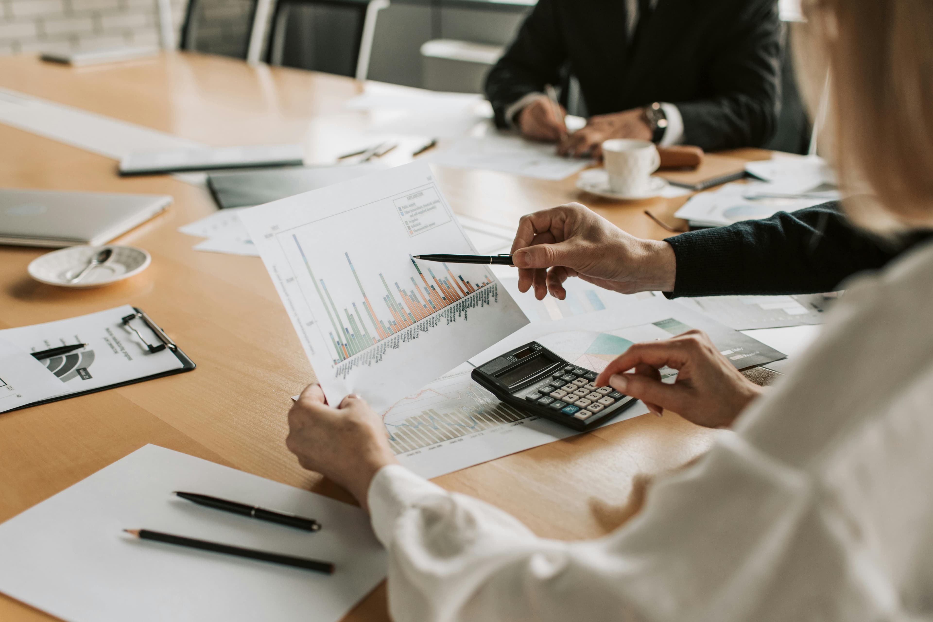 Colleagues reviewing charts around a meeting table